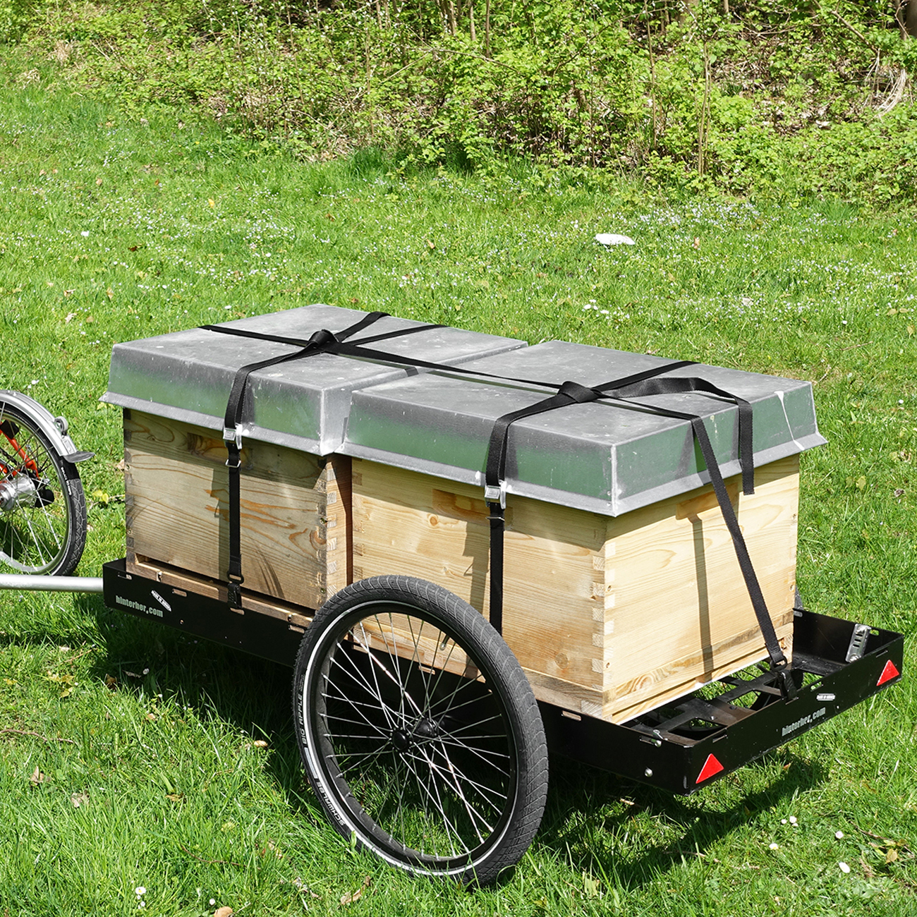 Ein Hinterher Fahrradanhänger transportiert Bienen Beuten